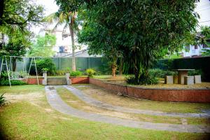 a garden with a tree and a stone path at The Cozy Villa in Ambalangoda