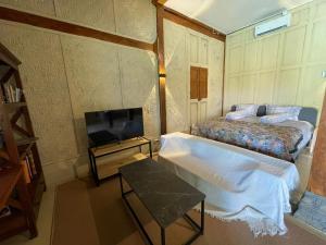 una piccola camera da letto con un letto e una TV di Villa Velo One a Watumurah