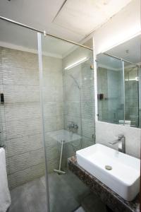 SadiqabadMidway Hotel Sadiqabad RYK的浴室配有洗手池和玻璃淋浴房