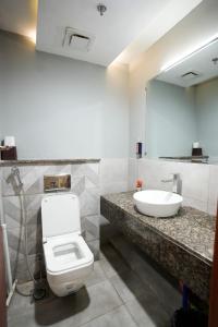 SadiqabadMidway Hotel Sadiqabad RYK的浴室里有马桶、洗手池和镜子。