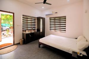a bedroom with a bed and a sliding glass door at Dolphins Turf in Mararikulam +54 photos