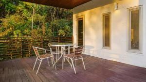 a patio with a table and chairs on a deck at Hongcheon inmylife dokche pension in Hongcheon +2 photos