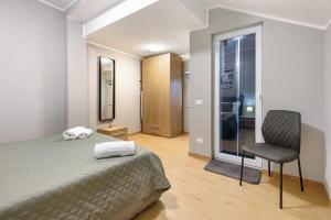 een slaapkamer met een bed en een stoel erin bij Casa Magenta Apartments in Valeggio sul Mincio