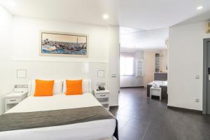 una camera con letto bianco e cuscini arancioni di Hostal Sans a Barcellona