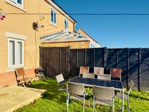 un cortile con tavolo, sedie e recinzione di Entire 3-Bed Home, 5 mins to City Centre, Sleeps 6, 2 Free Parking a Colchester