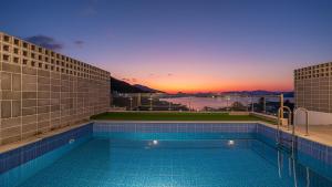 een zwembad met een zonsondergang op de achtergrond bij Yeosu Liposo Poolvilla in Yeosu +20 foto's