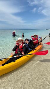 a group of people in a yellow kayak on the beach at DEWATI ROOMSTAY B&B in Lang Tengah