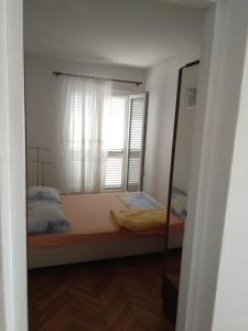 ein Spiegel, der ein Schlafzimmer mit einem Bett und einem Fenster reflektiert in der Unterkunft Apartment Lile in Kučište