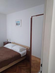 ein Schlafzimmer mit einem Bett und einem Spiegel in der Unterkunft Apartment Lile in Kučište