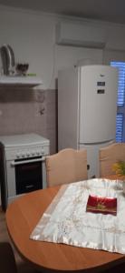 eine Küche mit einem Tisch und einem weißen Kühlschrank in der Unterkunft Apartment Lile in Kučište
