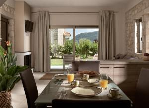 Un comedor con una mesa con vasos de jugo de naranja. en Avesta Private Villas - Niovi, en Vlikhón