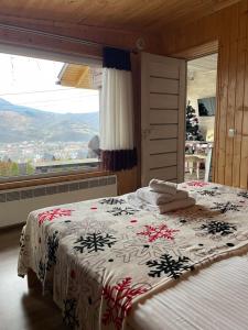 米日吉里亚Садиба Кичера的一间卧室配有一张床,床上铺有圣诞毯子