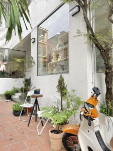 uno scooter arancione e bianco parcheggiato davanti a un edificio di The Dates Villa ad Ho Chi Minh