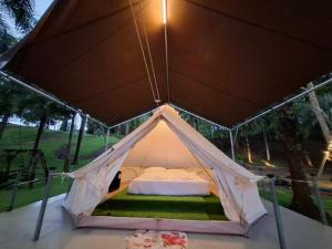 a white tent with a bed in it at Puprai Tarnnarm Resort in Thong Pha Phum