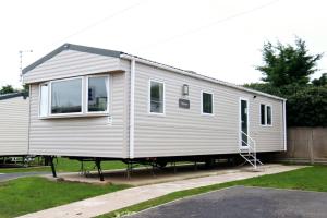 ein winziges Haus auf einem Wohnwagen in einer Auffahrt in der Unterkunft Birchington Vale Arizona in Westgate-on-Sea