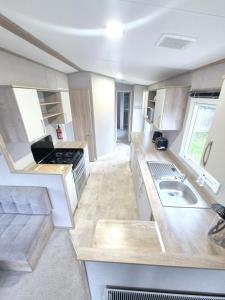 eine Wohnküche mit einer Spüle und einem Herd in der Unterkunft Birchington Vale Arizona in Westgate-on-Sea