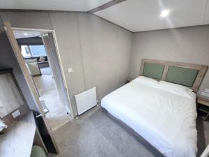 ein kleines Schlafzimmer mit einem Bett und einem Flur in der Unterkunft Birchington Vale Arizona in Westgate-on-Sea + 22 Fotos