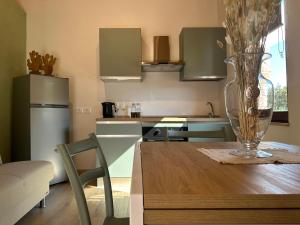 une cuisine avec une table avec un vase dessus dans l'établissement L'Albero di Gamelì Apartments, à Chiusi