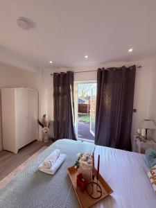 una camera da letto con un letto con un vassoio di cibo sopra di Cozy Escape Garden Flat a Birmingham