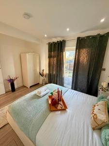 una camera da letto con un letto bianco con un vassoio sopra di Cozy Escape Garden Flat a Birmingham
