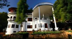 a large white house with a dome on top of it at The Hideaway Hotel in Egodagama