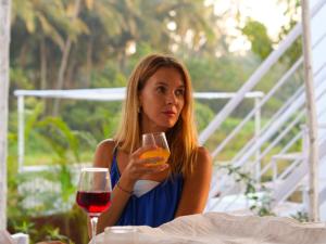 モージムにあるHome Of Gaiaのワイングラスを持ってテーブルに座っている女性