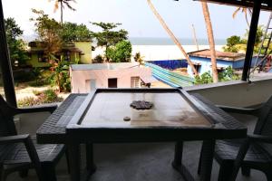 a table on a balcony with a view of the beach at Dolphins Turf in Mararikulam