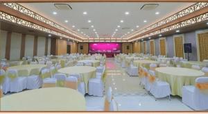 a banquet hall with white tables and white chairs at Kenari Asri Hotel in Kudus +121 photos
