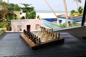 a chess board on a patio next to a beach at Dolphins Turf in Mararikulam