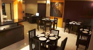 une salle à manger avec des tables et des chaises dans un restaurant dans l'établissement Grand Pinnacle Hotel, à Lat Krabang