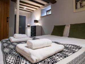 een slaapkamer met 2 bedden en witte handdoeken bij Blists Hill Cottage Near Ironbridge Victorian Museum in Telford