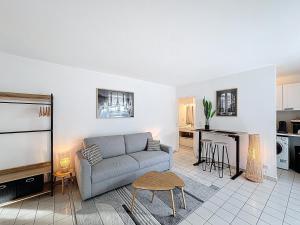 een woonkamer met een bank en een keuken bij Studio Moderne avec jardin et garage in Nanterre