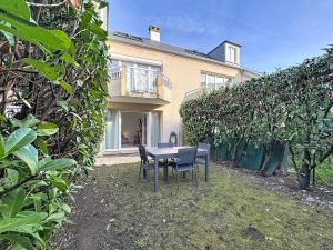 een tafel en stoelen voor een huis bij Studio Moderne avec jardin et garage in Nanterre