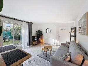 een woonkamer met een bank en een tafel bij Studio Moderne avec jardin et garage in Nanterre