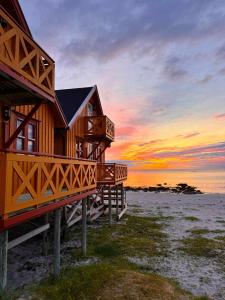 una casa de madera en la playa al atardecer en Bleik Sea Cabins, en Bleik