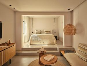 a bedroom with a bed and a couch at Minos Beach Art Hotel, a Member of Design Hotels in Agios Nikolaos +106 photos