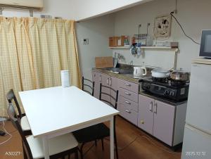 eine kleine Küche mit einem Herd und einem Tisch in der Unterkunft marusan houseマルさんの家 in Osaka + 6 Fotos