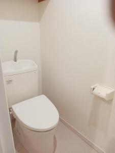 ein Badezimmer mit einer weißen Toilette in einem Zimmer in der Unterkunft marusan houseマルさんの家 in Osaka