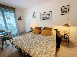 a bedroom with a bed and a large window at Appartement centre Orsay in Orsay