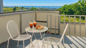 einen Tisch mit 2 Stühlen und Getränke auf dem Balkon in der Unterkunft Donghae Hill Stay Pension in Donghae