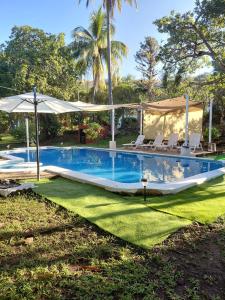 een zwembad met ligstoelen en een parasol bij Jardín Escondido in La Libertad