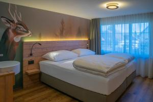 a bedroom with a bed with a deer head on the wall at Gasthof zum Reh - Self Check-in  +104 photos