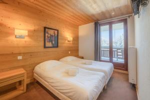 ein Schlafzimmer mit zwei Betten und einem Fenster in der Unterkunft l'Ours Bleu C21 - Ski In Ski Out - Happy Rentals in Vallorcine