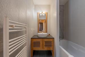 ein Badezimmer mit Waschbecken und Spiegel in der Unterkunft l'Ours Bleu C21 - Ski In Ski Out - Happy Rentals in Vallorcine + 25 Fotos