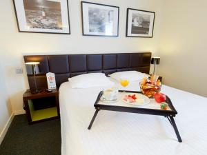 a hotel room with a tray of food on a bed at Kyriad Hôtel Orly Aéroport - Athis Mons in Athis-Mons