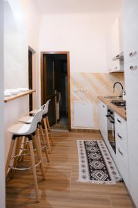 a kitchen with stools and a table in a kitchen at Marcos Apartments I Bathtub in Bedroom experience in Făgăraş +57 photos