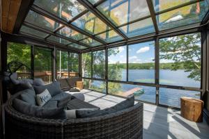 a glass house with a view of the water at Lakefront Big Bass Lake Dock Games in Gouldsboro +69 photos