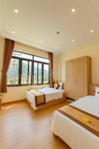 Un dormitorio con dos camas y una gran ventana. en Đức Khôi Hotel, en Cao Bằng 63 fotos más