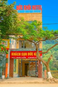 Un motel con falda escocesa azul y un árbol enfrente. en Đức Khôi Hotel, en Cao Bằng