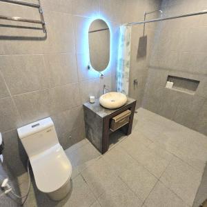 Un baño con inodoro, lavabo y espejo. en 3 Bedroom Private Pool Villa in Mengwi Kapal, en Kapal 8 fotos más